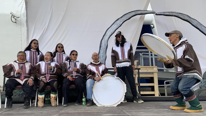 رجال ونساء من شعب الإنويت يغنون ويقرعون الطبول.