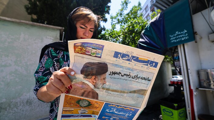 Une femme lit un journal qui annonce la mort du président.