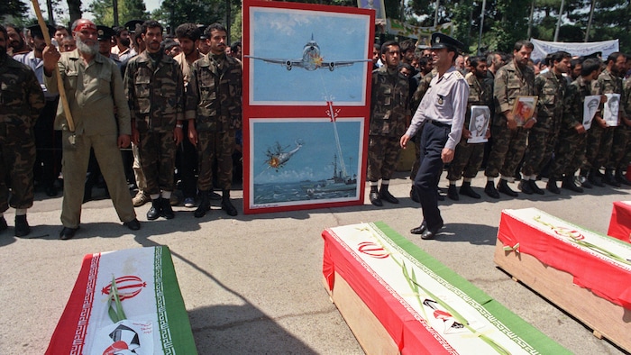 Soldiers gathered in front of four coffins. conflict israel-iran: strait ormuz, strategic