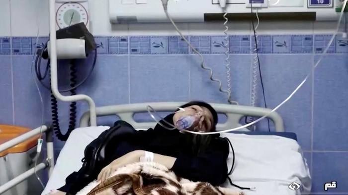 Jeune femme sur un lit d'hôpital avec des tubes sur le visage.