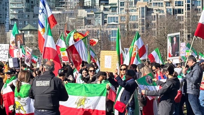 Des manifestants tiennent des drapeaux.