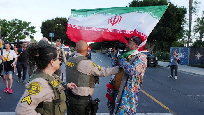 Des policiers tentent d'empêcher un opposant iranien de s'approcher d'un stade où s'entraînent l'équipe nationale de l'Iran à Carson, en Californie, à la veille de leur premier match prévu à Los Angeles.