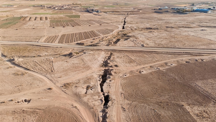 Vue aérienne de champs, avec une large craque au sol, le 14 novembre 2025.