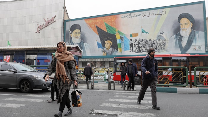 Des passants marchent devant une fresque murale qui représente le guide suprême iranien, l'ayatollah Ali Khamenei, dans une rue de Téhéran, le 7 février 2026.