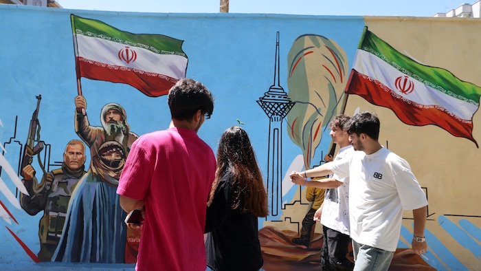 Des Iraniens passent devant une fresque murale anti-américaine et anti-israélienne peinte sur un mur de la capitale, Téhéran.