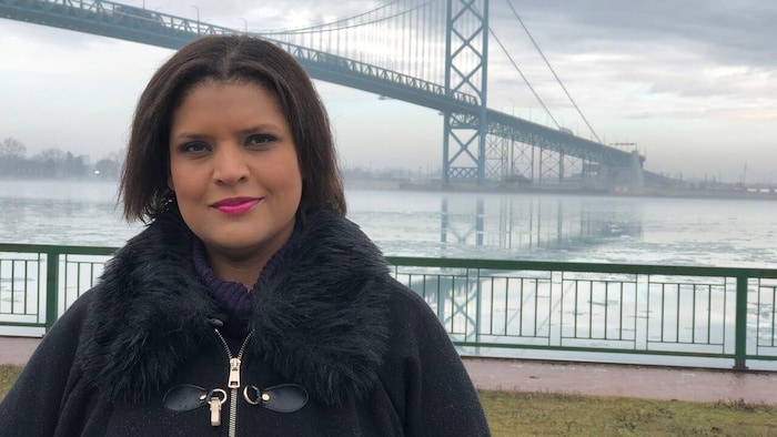Irene Moore-Davis pose devant la rivière Détroit et le pont Ambassador.