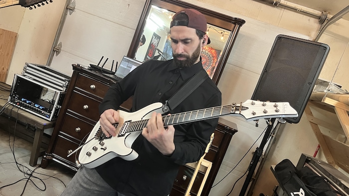 Nataniel Laroche joue de la guitare.