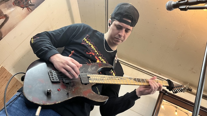 Philippe Simard joue de la guitare.