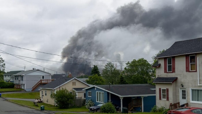 Un nuage de fumée noire provenant de la raffinerie Irving Oil vu d'un quartier résidentiel.