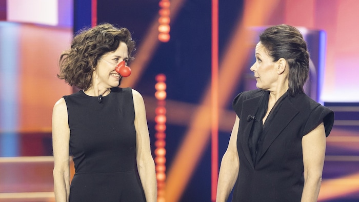 Les deux femmes, dont une porte un nez de clown, se regardent sur scène. 