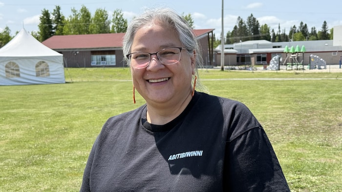 Une femme regarde la caméra en souriant.  