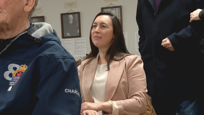 La ministre assise, écoutant la présentation.