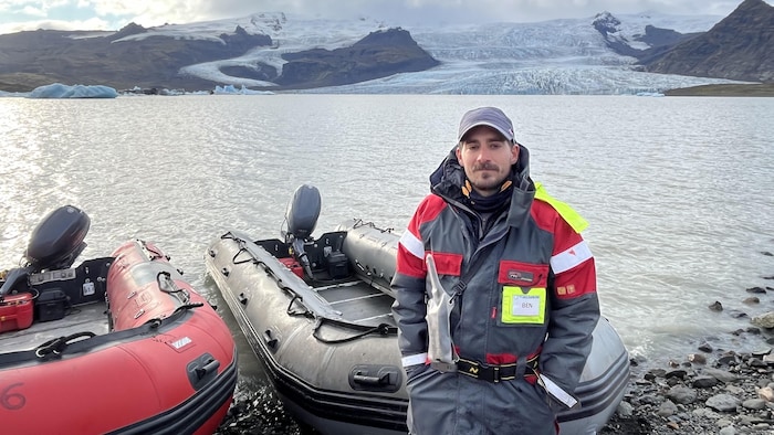 Benoît Robert devant des bateaux pneumatiques et un glacier.