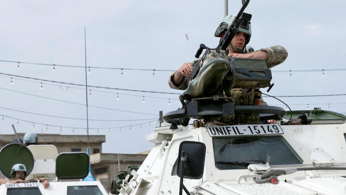 Un soldat de la Force intérimaire des Nations Unies au Liban debout sur un véhicule militaire, une mitraillette à la main.