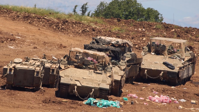 Quatre chars d'assaut, sur une terre sans végétation. 