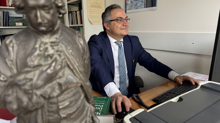 Gian Luigi Gatta, professeur titulaire de droit pénal à l'Université de Milan et président de l'Association italienne des professeurs de droit pénal, est assis à son bureau.