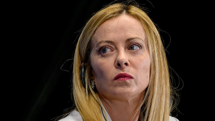 Une femme en gros plan sur fond noir.