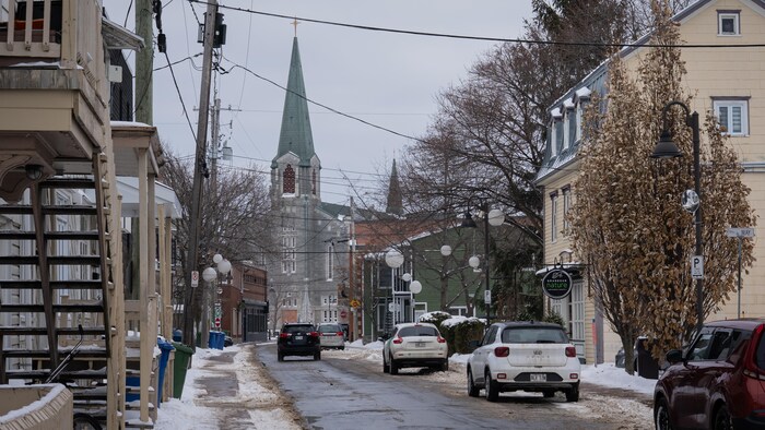 Une église au bout d'une rue d'un centre-ville en hiver.