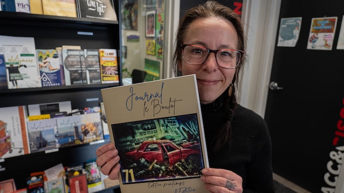 Une femme tient un livre dans ses mains.