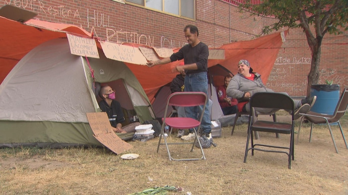 Des personnes sont installées dans des tentes à l'extérieur de l'aréna Robert-Guertin, dans le secteur Hull.