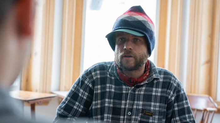 Un homme barbu avec un chapeau et une casquette.
