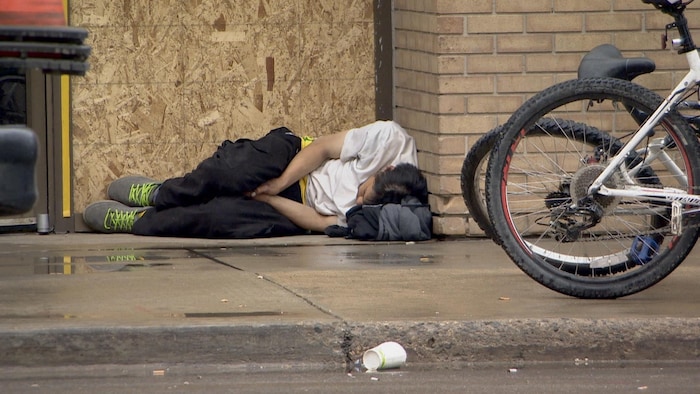 Une personne sans-abri dort dans la rue à Saskatoon, en Saskatchewan, le 9 juin 2022.