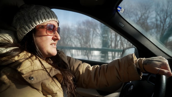 Une femme conduit une voiture. 