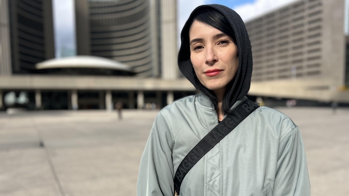 Diana Chan McNally est devant l'Hôtel de Ville de Toronto. 