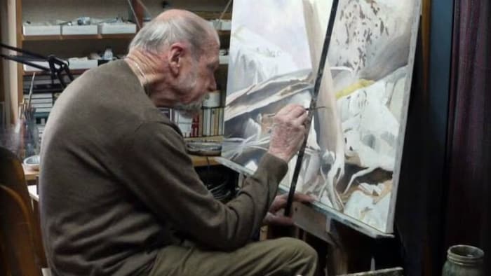 Ivan Wheale peint un tableau.