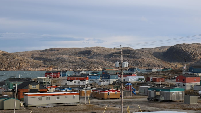 Des maisons colorées, la baie et juste après, des collines.