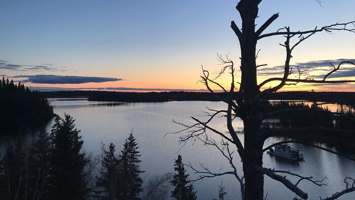 Coucher de soleil au-dessus d'un lac et une forêt.