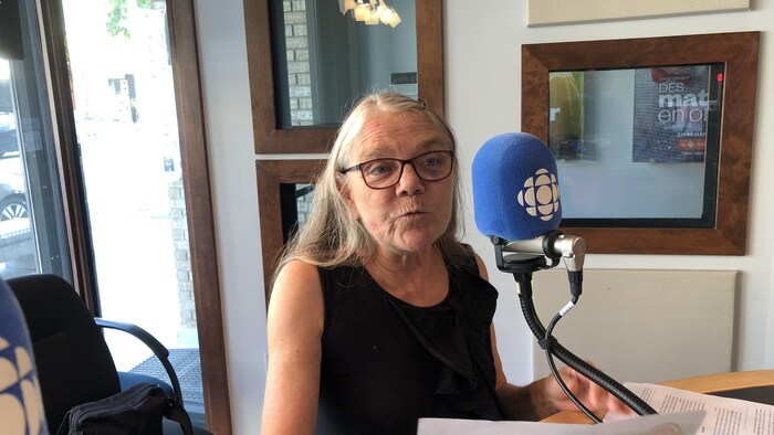 Une femme parle dans un micro.