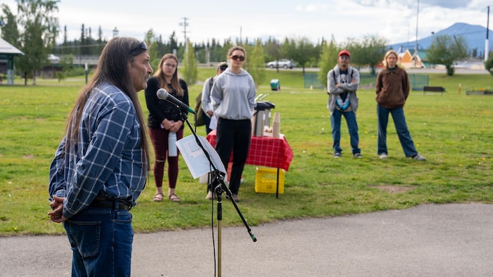 Jack Bogaard parle devant un public dans un parc de Whitehorse.