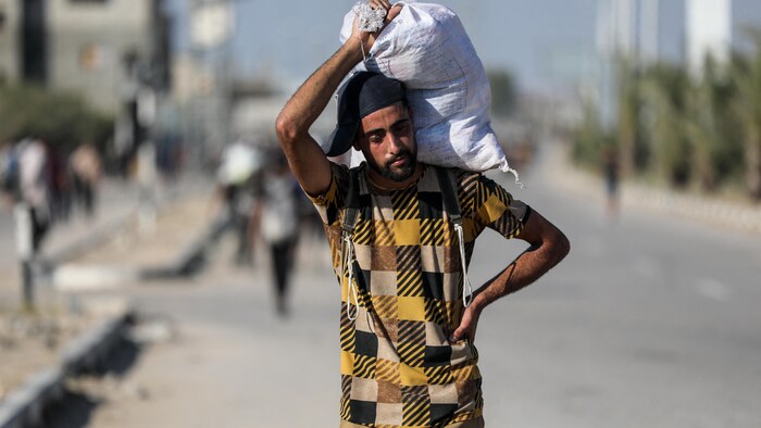 Un homme palestinien transporte un sac de nourriture.