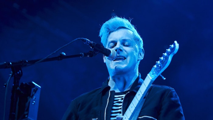 Jack White chante dans un microphone.