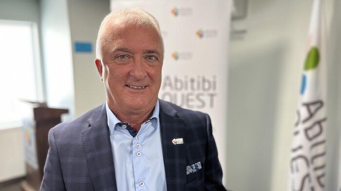 Jaclin Bégin devant une oriflamme aux couleurs de l'Abitibi-Ouest.