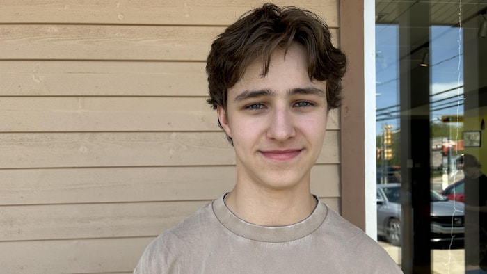 Un adolescent devant un mur extérieur de restauration rapide.
