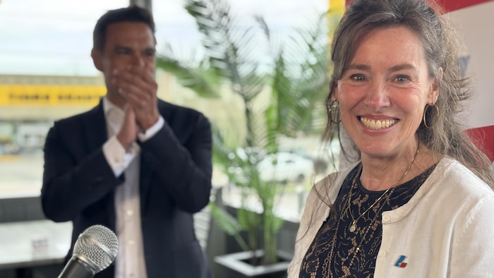 Jacqueline Belleau avec Charles Milliard en arrière-plan.