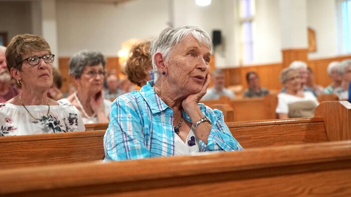 Une femme sur un banc d'Église.                               