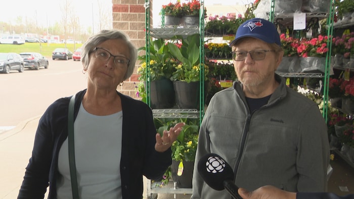 Jacqueline et Donald Kenny devant une épicerie.