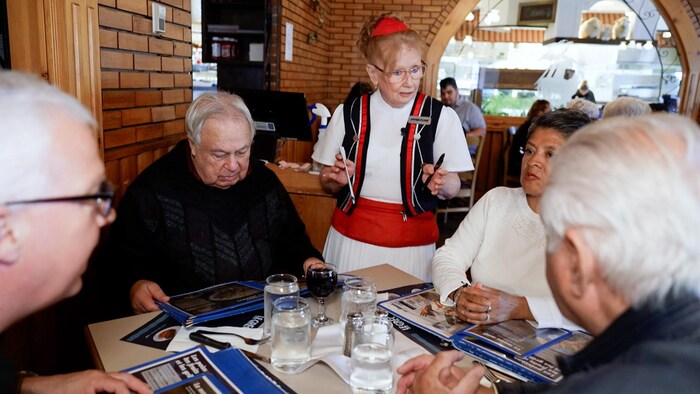 Jacqueline Pelletier en train de répondre à des clients sur une table.