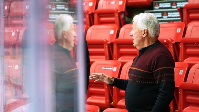 Jacques Blais discute près de sièges vides à l'aréna des Huskies.