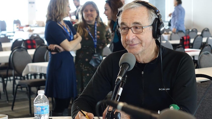 Jacques Chartier derrière un microphone.