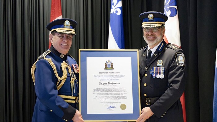 M. Duchesneau, en uniforme, tient un cadre.