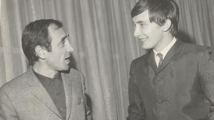 Photo en noir et blanc de deux hommes qui se parlent.