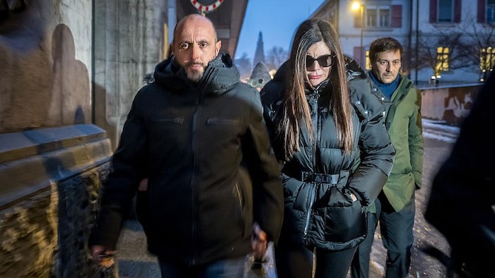Deux personnes marchent dans la rue, au petit matin, en se tenant la main.