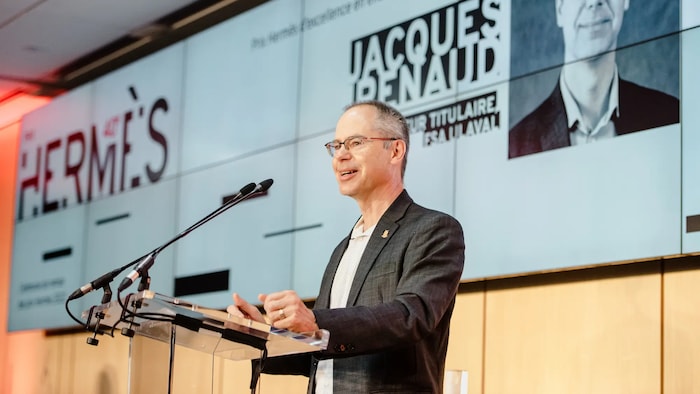 Jacques Renaud donne une conférence. 