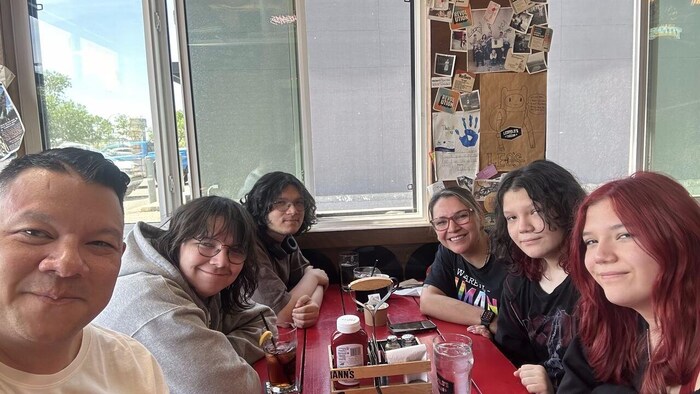 Une famille de six personnes assises autour d’une table.
