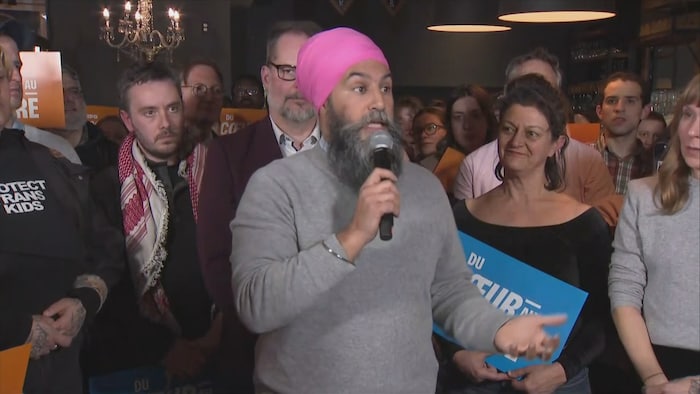 Jagmeet Singh parle dans un micro et est entouré de partisans. 