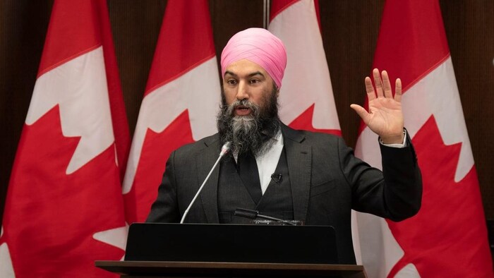 A man speaks at the microphone during a conference.